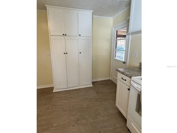 a view of a kitchen with white cabinets