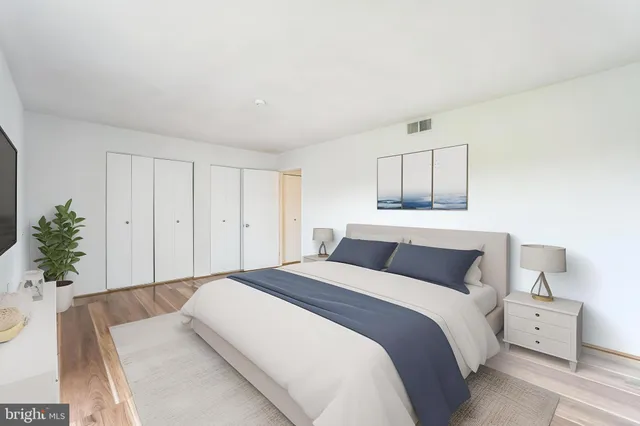 a bedroom with a bed and a potted plant