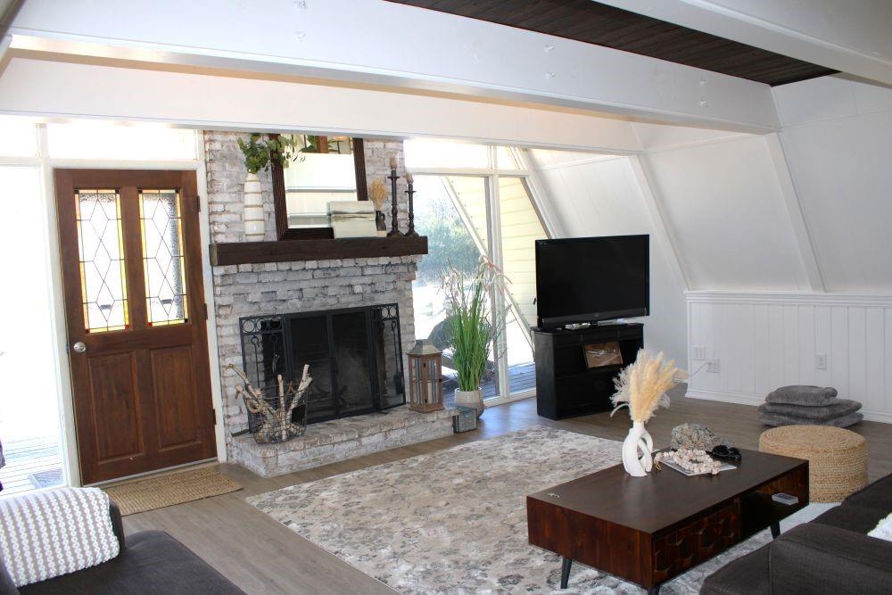 2629 Fox Point Road Quinlan, TX 75474 - Photo 7 of 30 a living room with furniture a flat screen tv and a fireplace