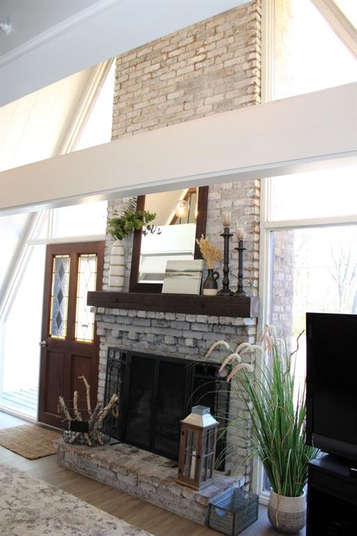 2629 Fox Point Road Quinlan, TX 75474 - Photo 8 of 30 a living room with a fireplace a potted plant and a window