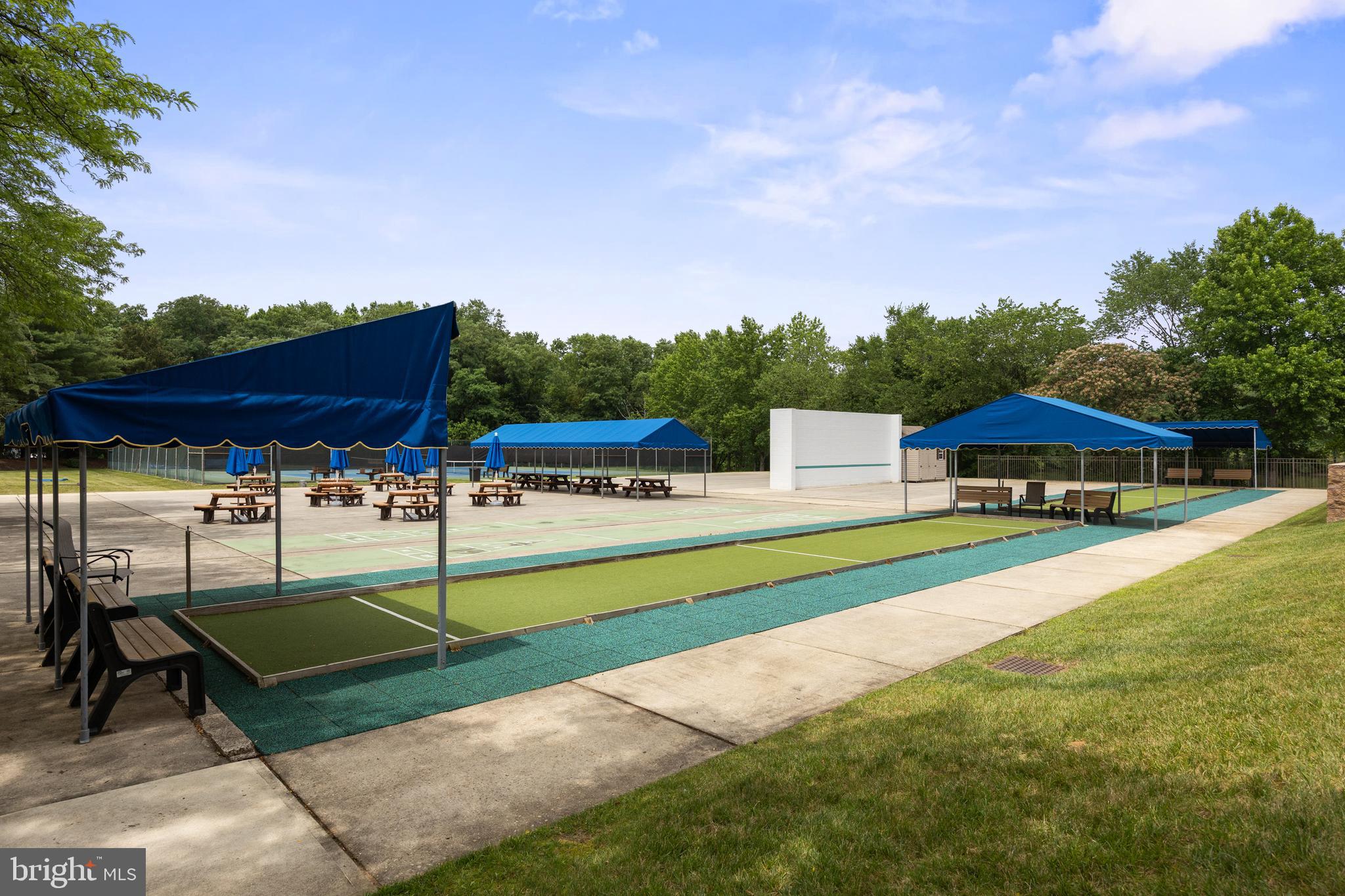 7 Covered Bridge Circle Columbus, NJ 08022 - Photo 36 of 40 a view of a swimming pool with a bench and lawn chairs under an umbrella