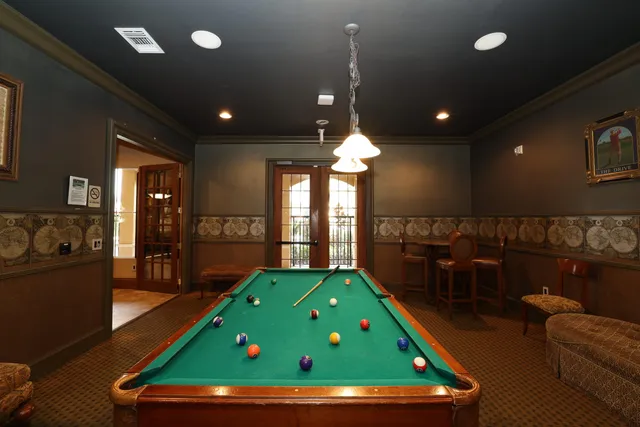 a room with pool table and windows