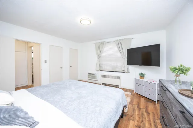 a bedroom with a flat screen tv and a bed