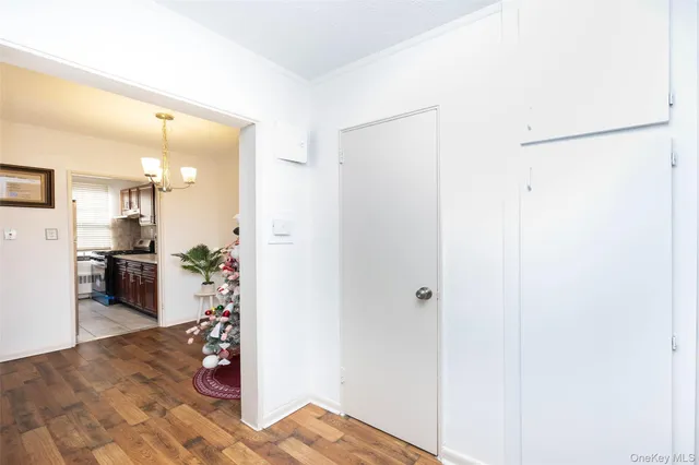 a view of a kitchen with refrigerator and wooden floor