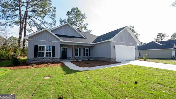 a front view of a house with yard and green space