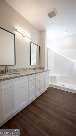 a bathroom with a granite countertop sink and a mirror