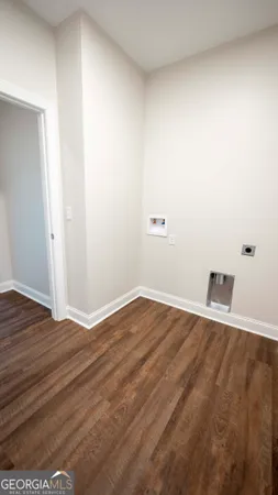 an empty room with wooden floor ceiling fan and windows