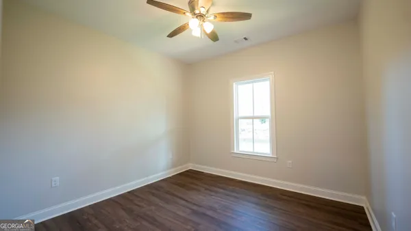 a view of an empty room with wooden floor