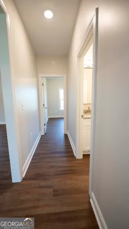 an empty room with windows and chandelier fan