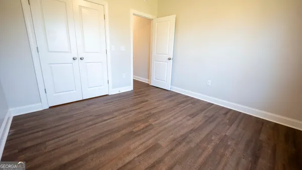 a bathroom with a granite countertop toilet a sink and a mirror