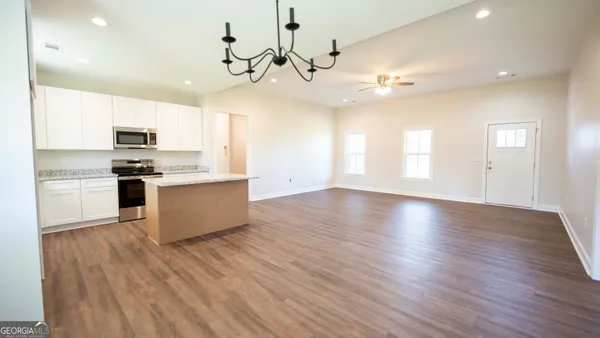 a large kitchen with hardwood floor and a refrigerator