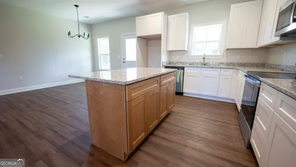 a kitchen with wooden floors and white cabinets