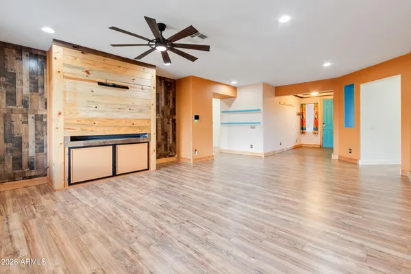 a kitchen with stainless steel appliances granite countertop a refrigerator a stove and a sink with wooden floor