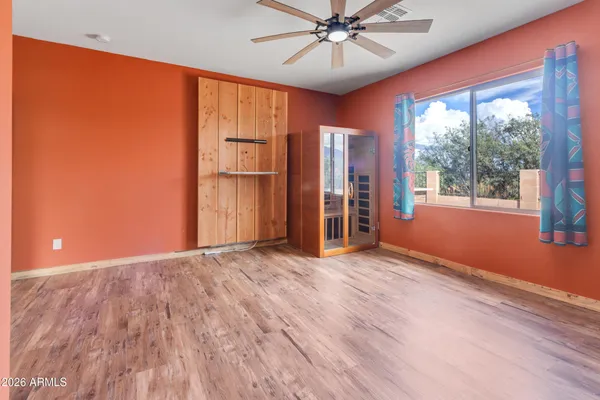 a view of an empty room with window and wooden floor