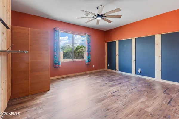 a bedroom with a large bed and a ceiling fan