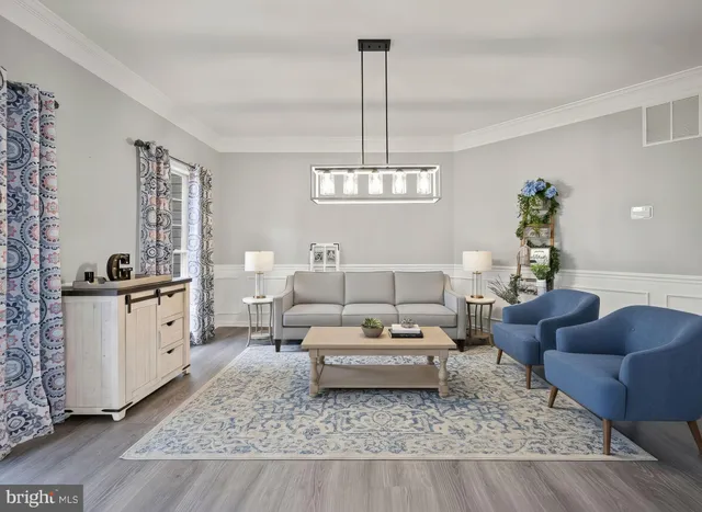 a kitchen with stainless steel appliances granite countertop a refrigerator a microwave a stove and a dining table with wooden floor