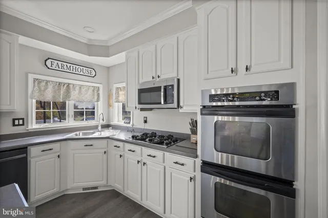 a view of a hallway with wooden floor and a living room