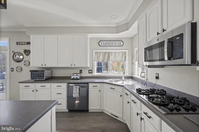 a spacious bedroom with a large bed a chandelier and windows