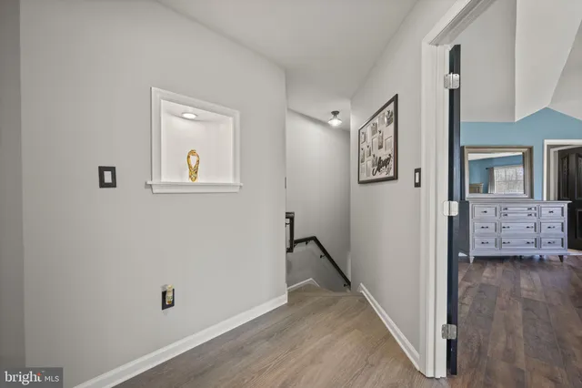 a view of a hallway with wooden floor and stairs