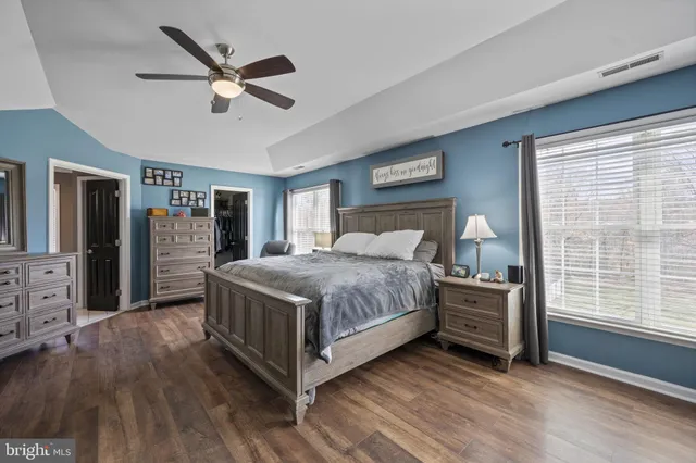 a bedroom with furniture a ceiling fan and a window