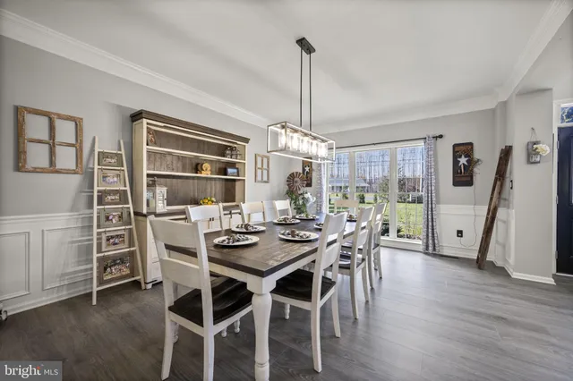 a kitchen with stainless steel appliances a dining table chairs stove and refrigerator