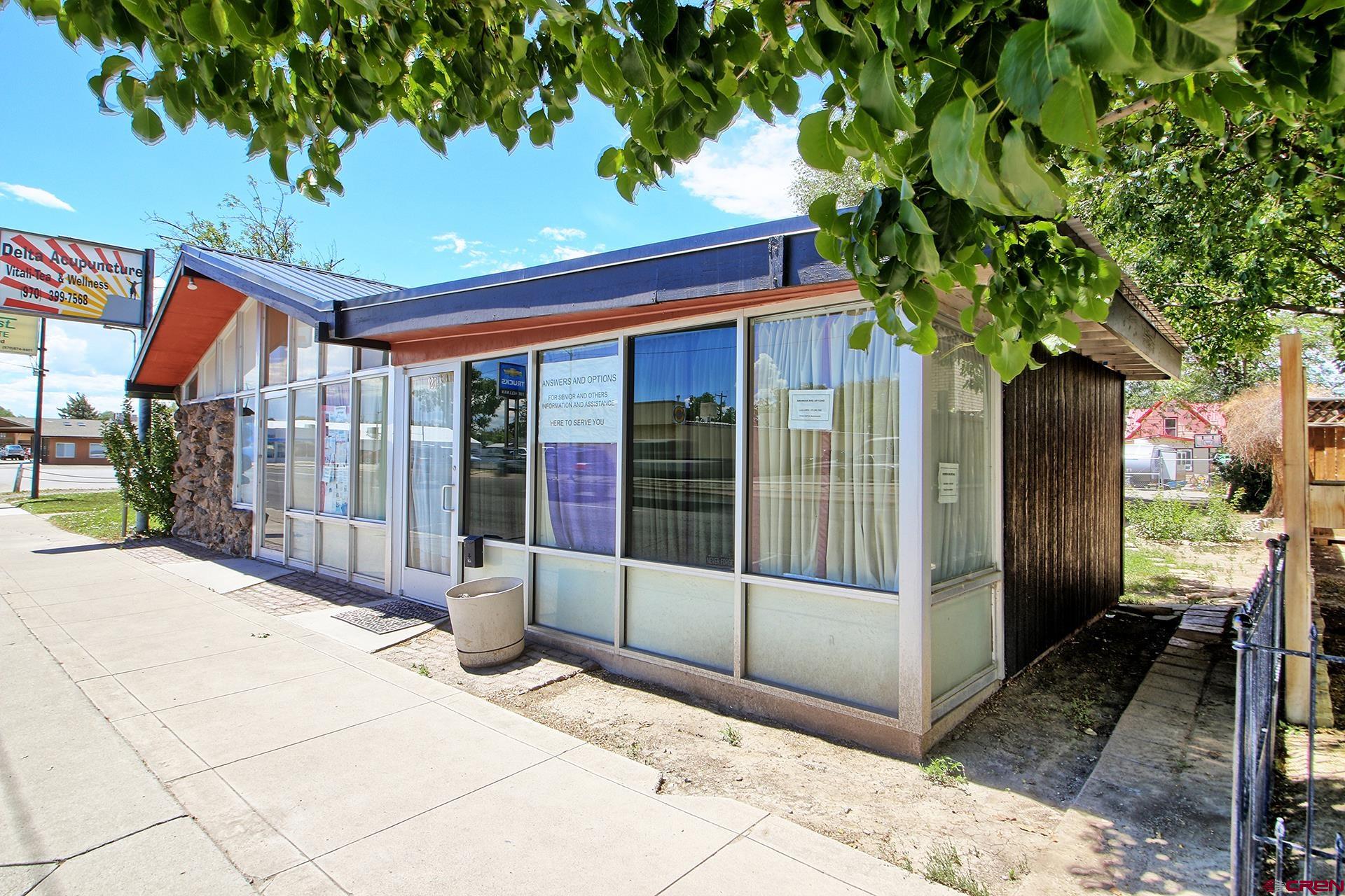 823 Main Street Delta, CO 81416 - Photo 1 of 32 a porch with a table and chairs under an umbrella