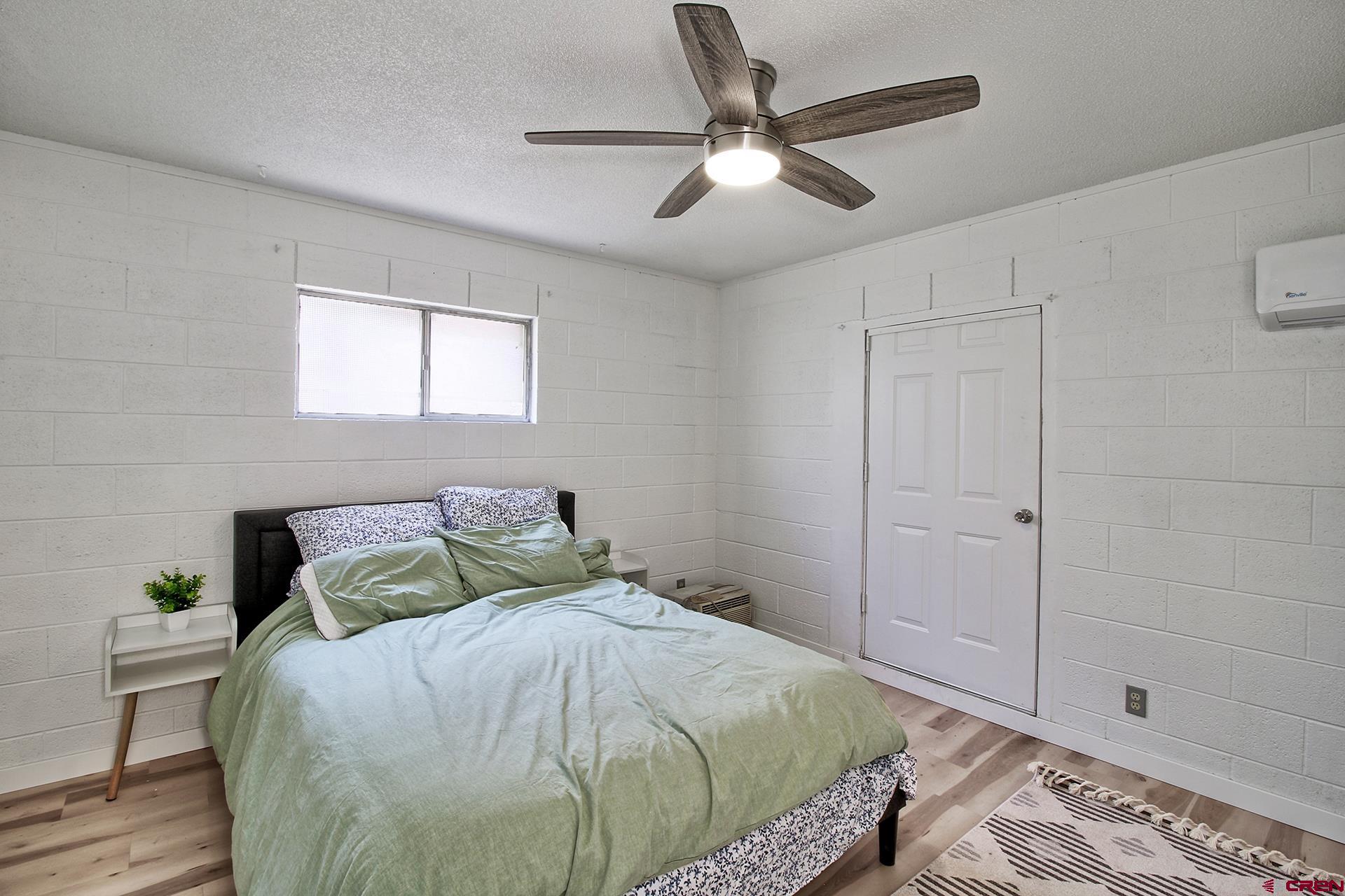 823 Main Street Delta, CO 81416 - Photo 15 of 32 a bedroom with a bed and a chandelier
