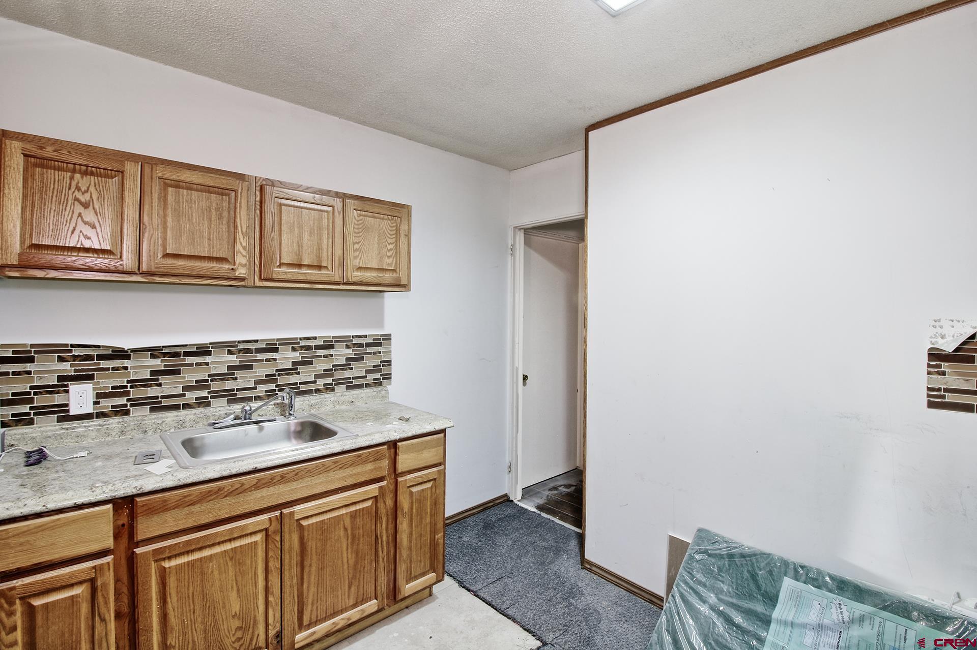823 Main Street Delta, CO 81416 - Photo 29 of 32 a kitchen with granite countertop a sink and a stove