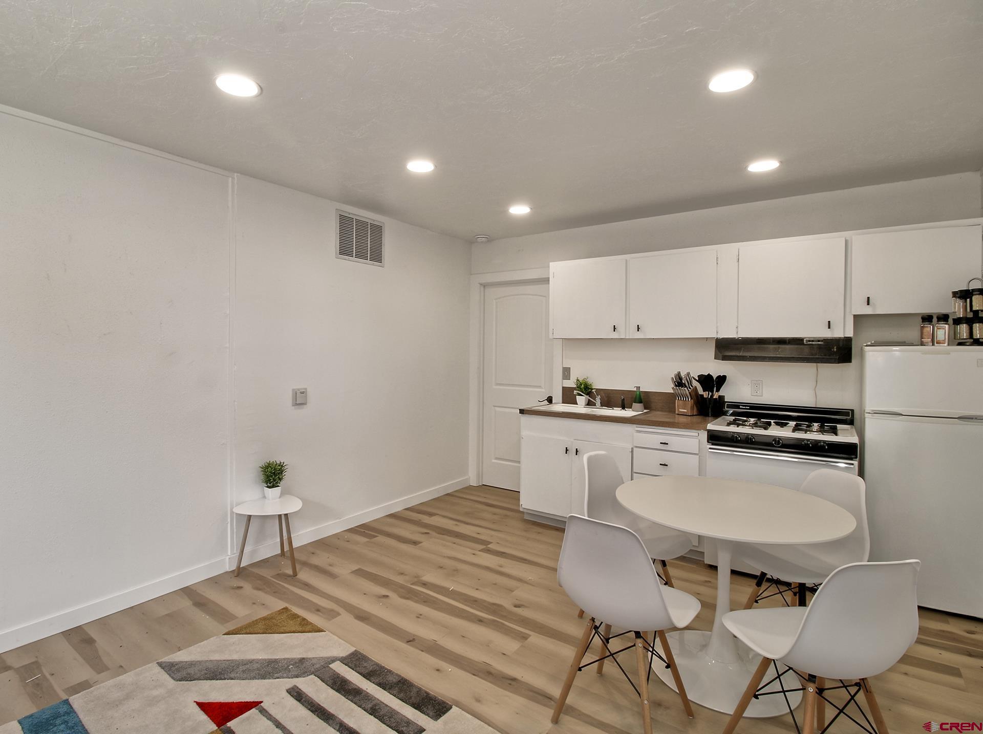 823 Main Street Delta, CO 81416 - Photo 10 of 32 a kitchen with granite countertop white cabinets and white appliances