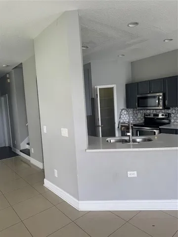 a view of a kitchen with stainless steel appliances granite countertop a refrigerator and a stove