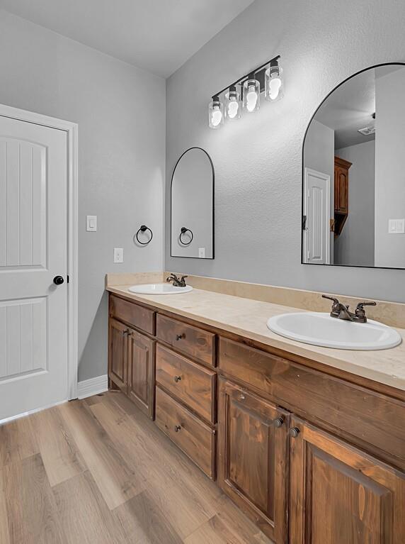 550 Hunton Lane Robinson, TX 76706 - Photo 26 of 35 Bathroom featuring double vanity and wood finished floors