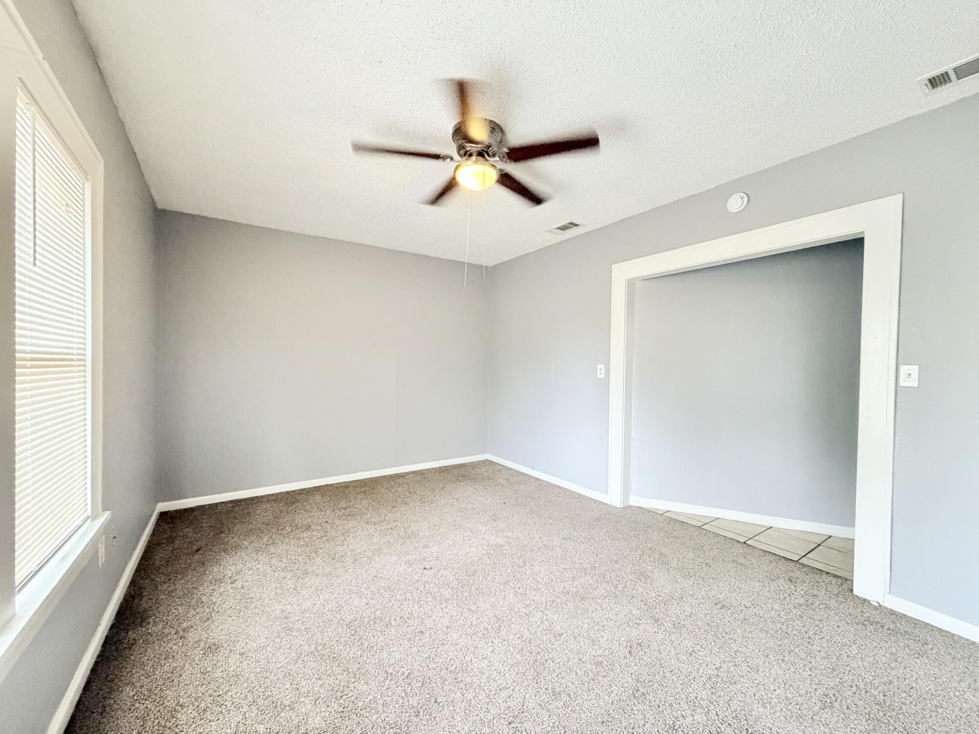 2119 15th Street Lubbock, TX 79401 - Photo 9 of 15 an empty room with windows and fan
