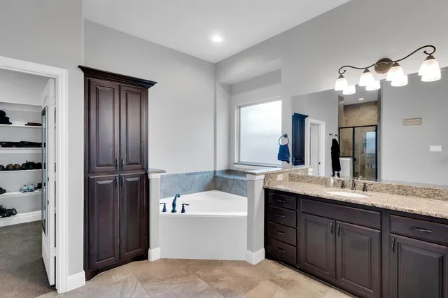 a bathroom with a tub sink and mirror