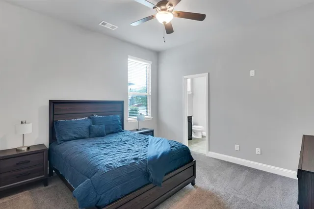a bedroom with a large bed and a chandelier