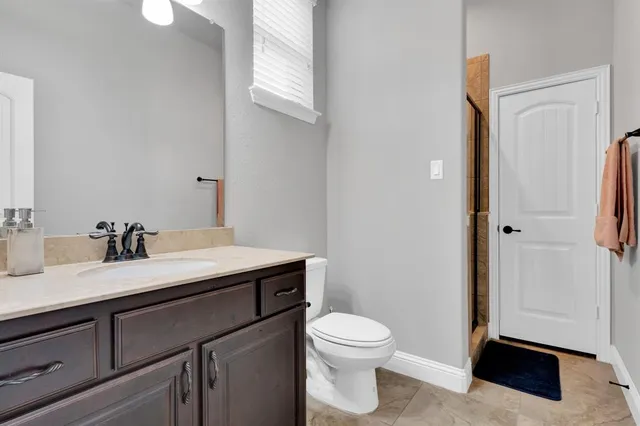 a bathroom with a toilet a sink and mirror