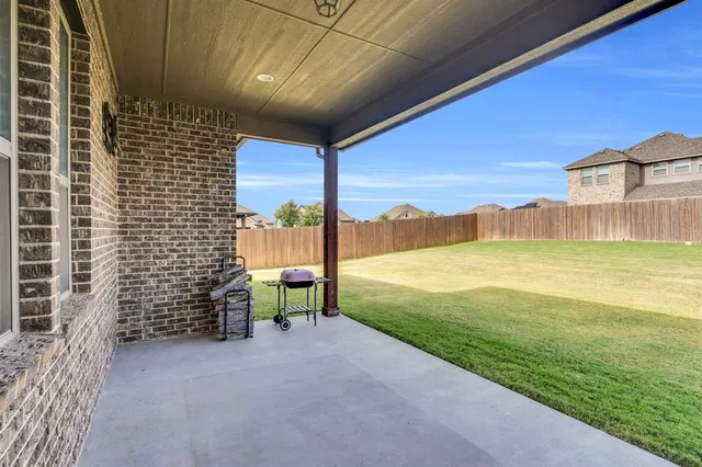 a view of a patio with a table and chairs under an umbrella