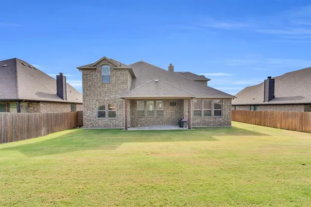 a view of a house with a big yard and a large tree