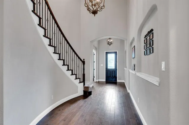 a view of a hallway with wooden floor and entryway