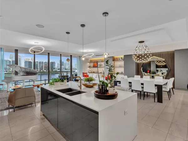 a kitchen with a dining table chairs and refrigerator