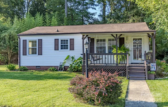 a view of a house with potted plants and a yard