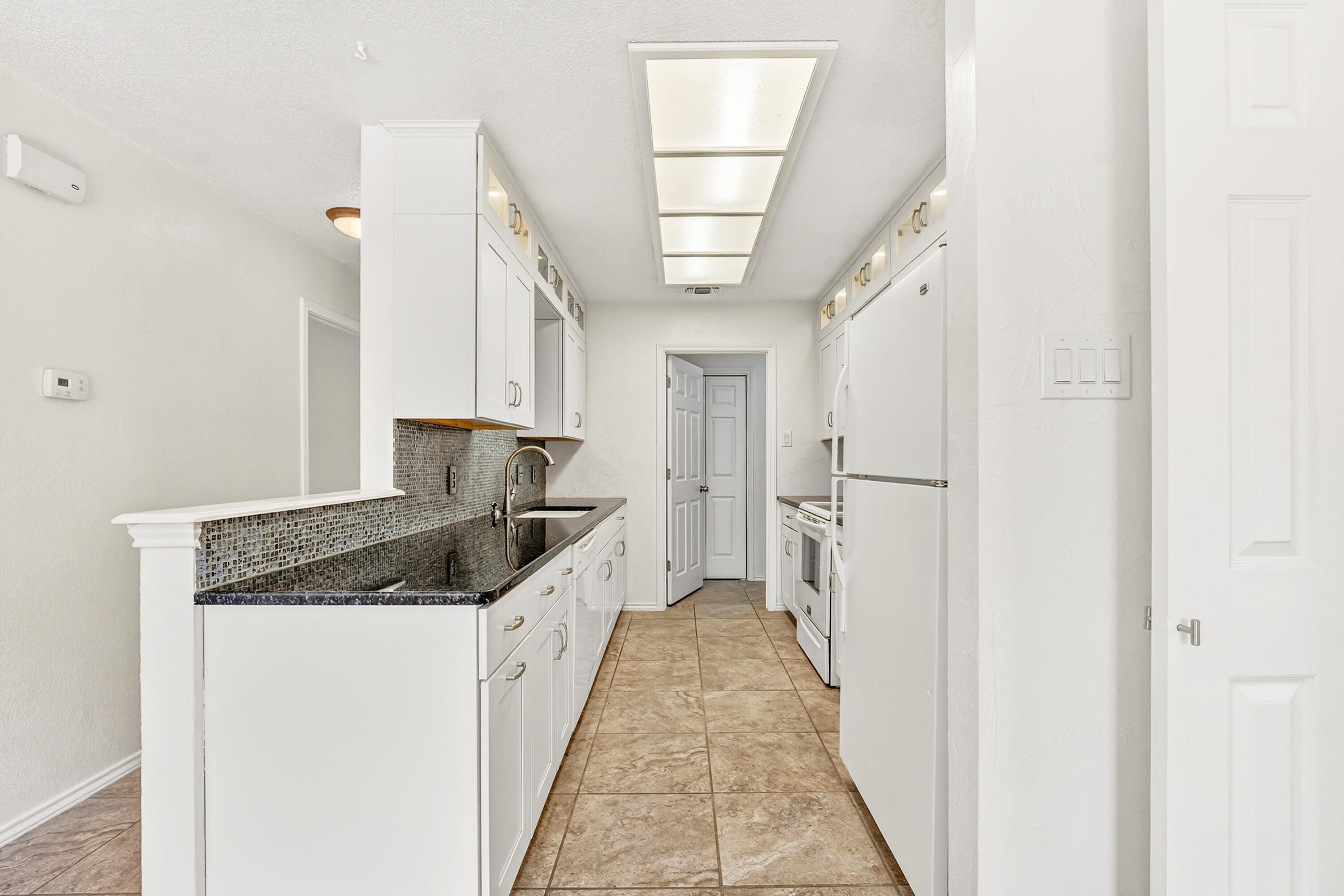 5221 84th Street Lubbock, TX 79424 - Photo 9 of 26 a kitchen with a sink and refrigerator