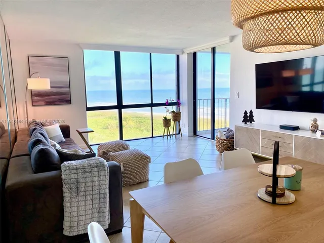 a living room with patio furniture and a flat screen tv