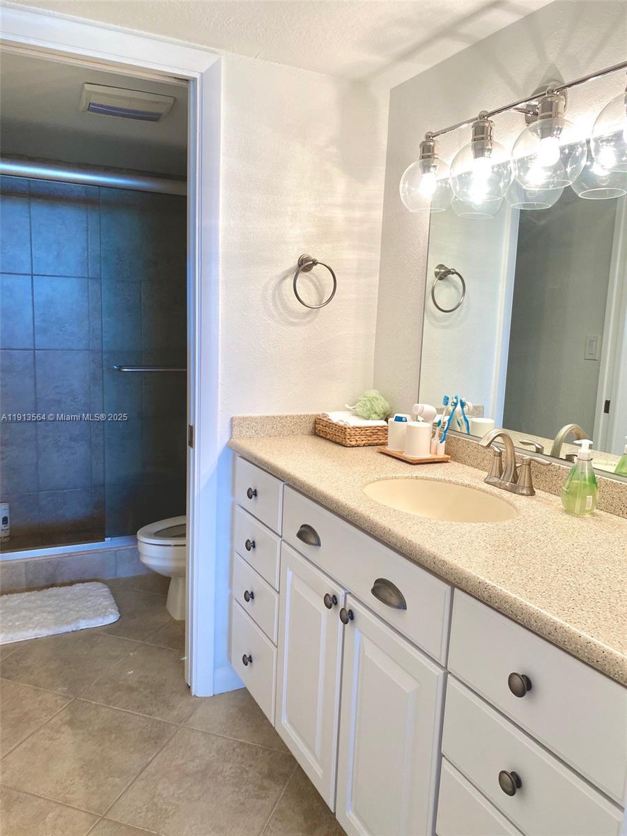 2800 North Hwy A1A, Unit 803 Fort Pierce, FL 34949 - Photo 24 of 35 a bathroom with a granite countertop sink a toilet and a mirror