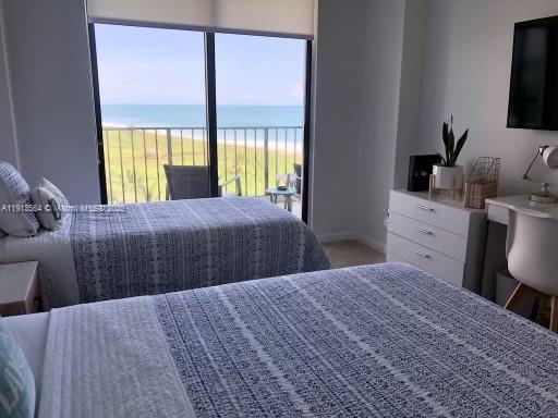 2800 North Hwy A1A, Unit 803 Fort Pierce, FL 34949 - Photo 8 of 35 a bedroom with a large bed and a flat tv screen on dresser next to a window