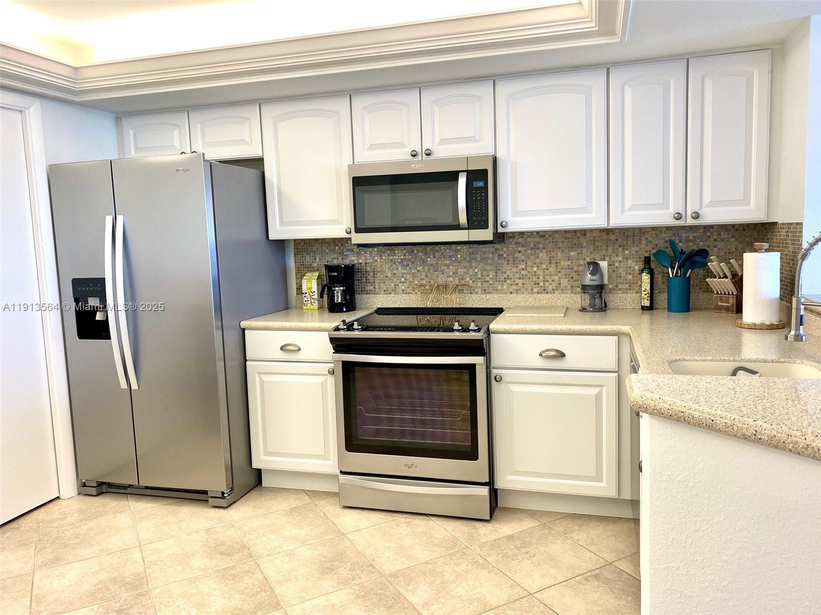 2800 North Hwy A1A, Unit 803 Fort Pierce, FL 34949 - Photo 9 of 35 a kitchen with stainless steel appliances granite countertop a stove a refrigerator and a microwave
