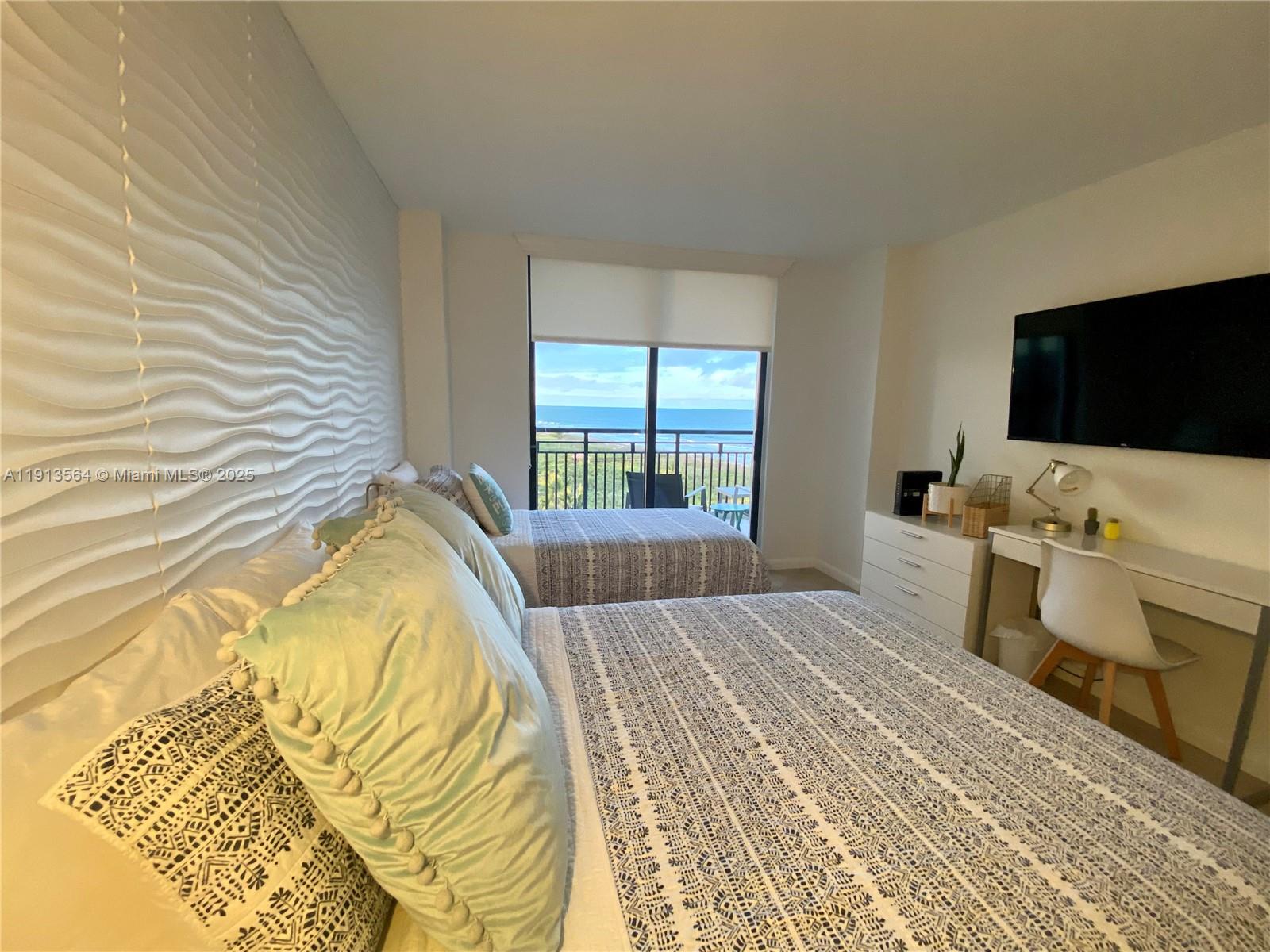 2800 North Hwy A1A, Unit 803 Fort Pierce, FL 34949 - Photo 10 of 35 a bedroom with a bed and flat screen tv