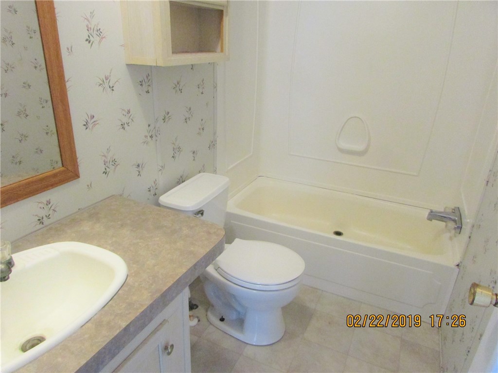 371673 Kings Ferry Road Hilliard, FL 32046 - Photo 16 of 34 a bathroom with a granite countertop sink toilet and shower