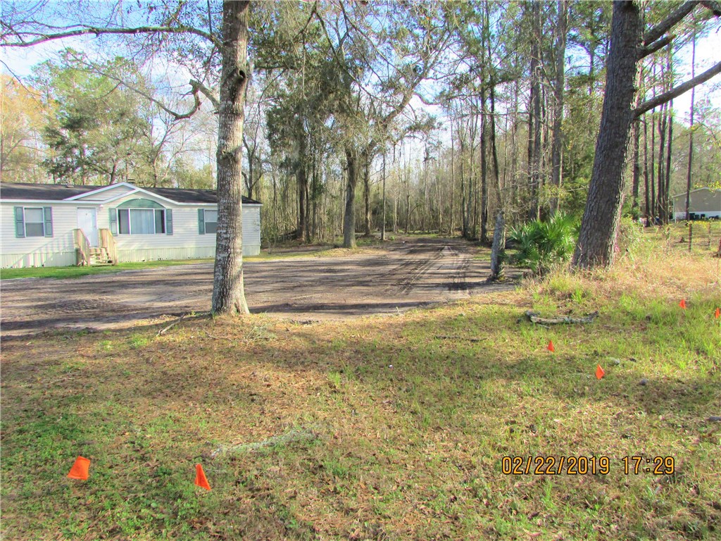 371673 Kings Ferry Road Hilliard, FL 32046 - Photo 30 of 34 a backyard of a house with lots of green space and plants