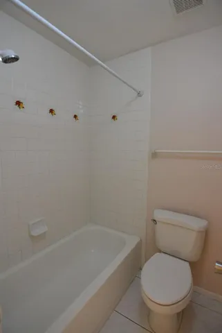 a white toilet sitting next to a bath tub