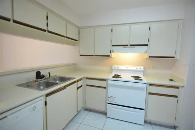 a kitchen with cabinets appliances a sink and a stove